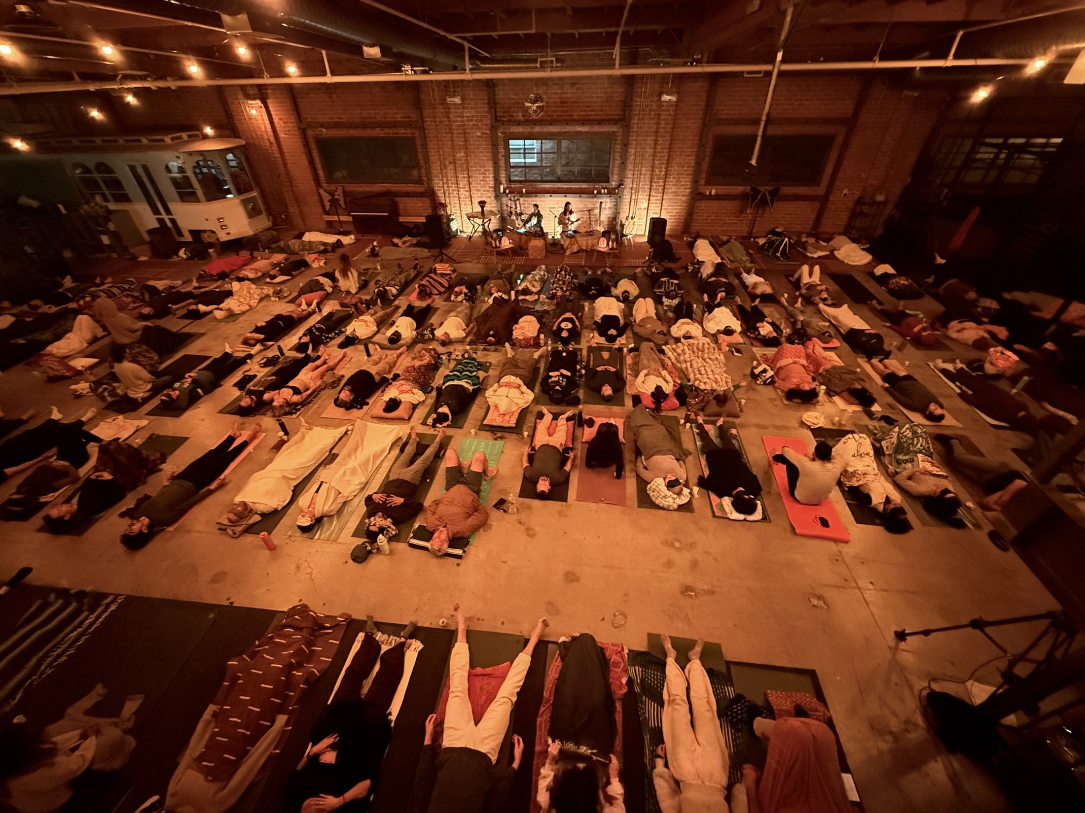 A full room of participants resting during a live breathwork concert