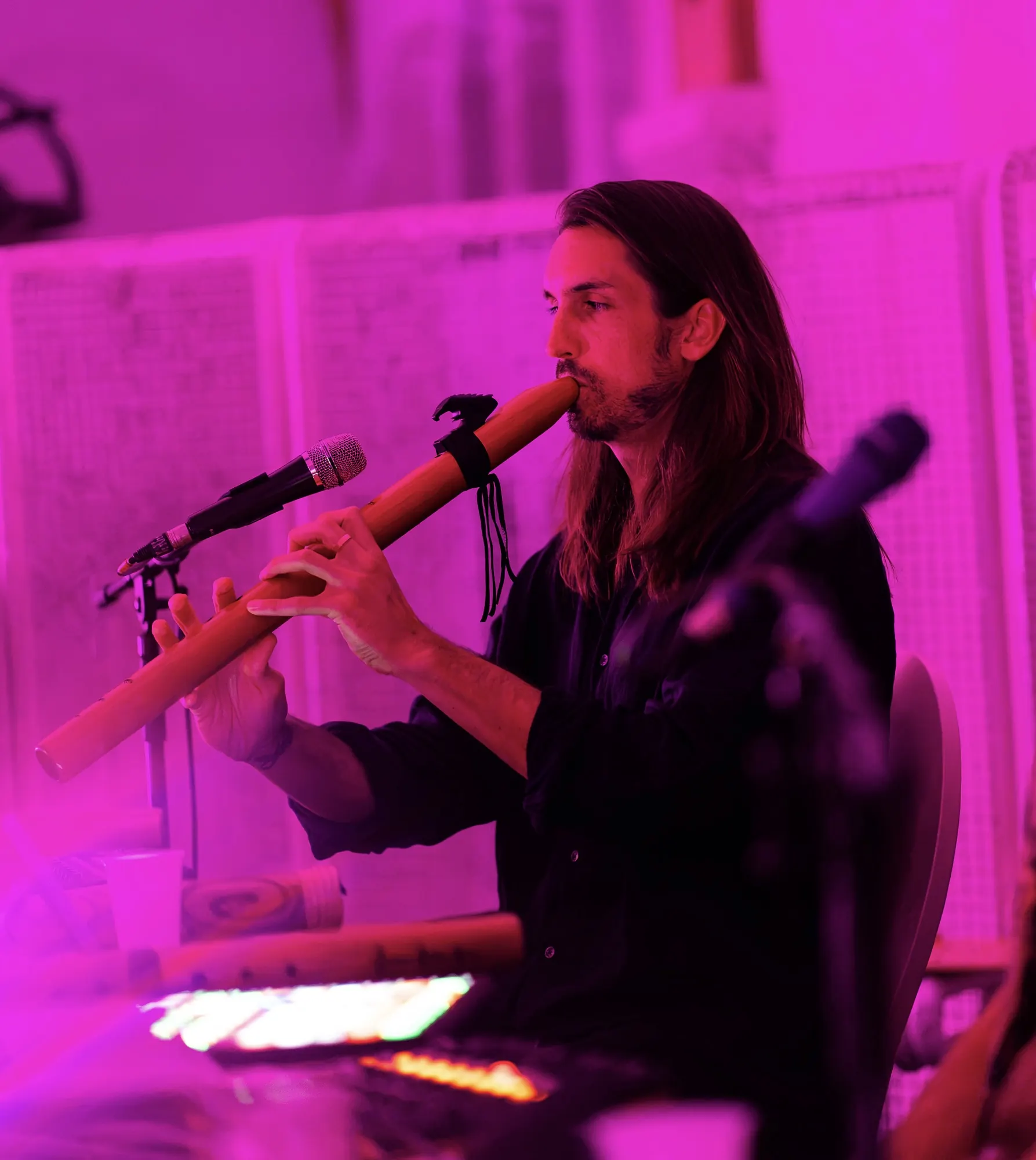 Sandy playing flute under magenta light in Budapest